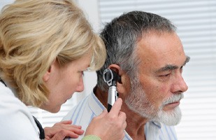 Male patient getting his ears examined