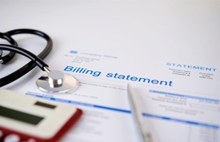 Medical billing statement with calculator and pen