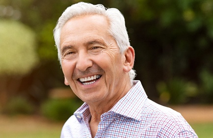 Older man with wrinkles smiling.