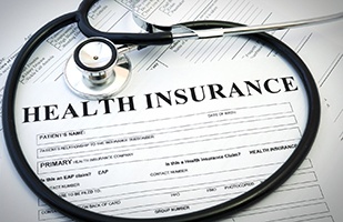 Close-up of health insurance claim for underneath stethoscope