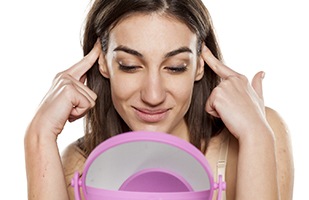 Woman holding her ears, thinking about getting otoplasty
