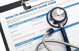 Health insurance claim form on clipboard with stethoscope