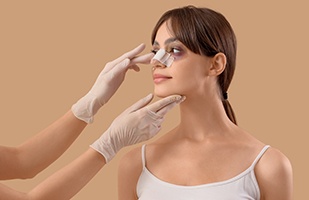 Woman wearing a bandage on her nose after rhinoplasty