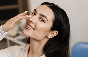Happy woman touching her nose