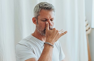 Mature man doing breathing exercises through his nose