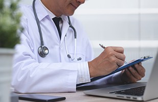 Doctor taking notes on clipboard