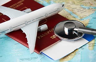 Stethoscope, passport, and airplane model on world map