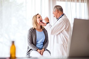 Doctor examining patient’s throat