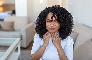 Woman suffering sore throat, considering undergoing a tonsillectomy