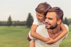 Portrait of handsome dad with son after treatment by facial plastic surgeon