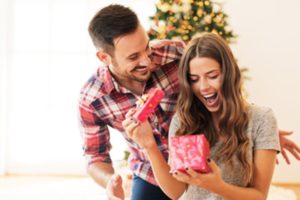 Man and woman opening gift of a visit to a facial plastic surgeon