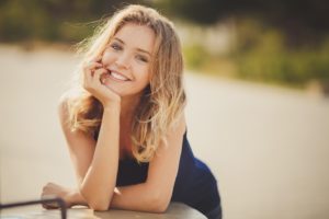Smiling, beautiful young woman after visiting facial plastic surgeon