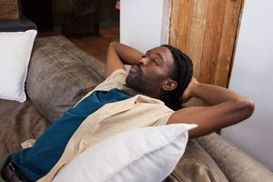 Man quietly relaxing at home on sofa